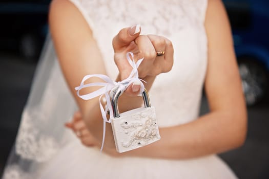 The bride is holding a white closed padlock. Wedding concept