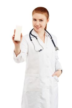 Portrait of a young female doctor in a white coat holding in hands a box with a new drug against a white background. Doctor holding an empty box with any medicine without labels isolated on white background. Medicine for cold