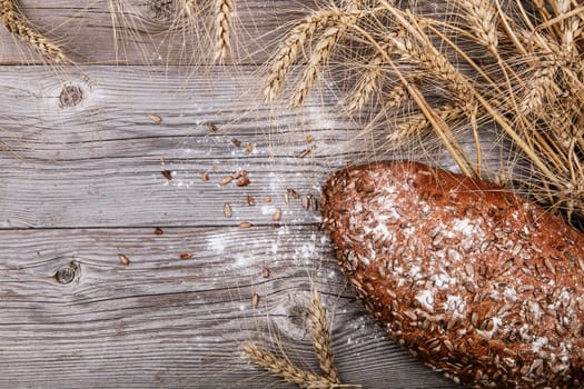 Bread with sunflower seeds on textured wooden background. rustic style