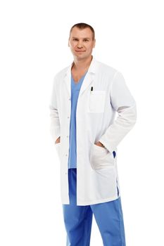 Portrait of a young male doctor in a white coat and blue scrubs against a white background