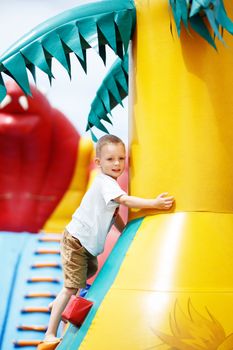 Little cool boy have fun and play on an inflatable trampoline