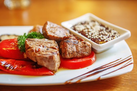 Fried piece of meat with vegetable salad on a plate