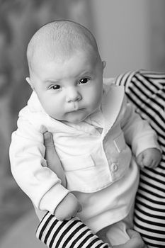 Portrait of elegant baby boy in white suit. Black and white photography