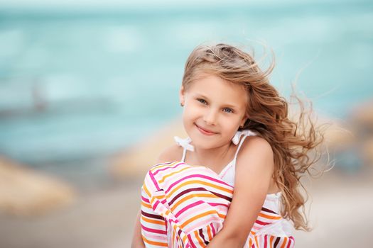 Portrait of a beautiful blonde little girl on the beach at a tropical resort. The concept of rest.