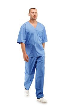 Full length portrait of a young male doctor in a medical surgical blue uniform in motion leaving the operating room against a white background