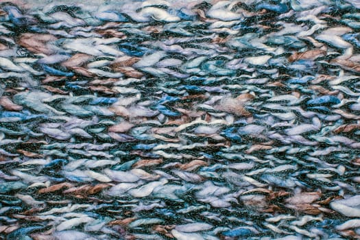 Close up on knit woolen fur texture. Color melange fluffy woven thread sweater or scarf as a background.
