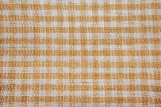 The texture of checkered fabric as a background. Checked fabric tablecloth. Fabric in a small square. Texture plaid fabric. Texture background of kitchen towels
