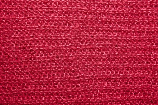 Close up on knit woolen fur texture. crimson fluffy woven thread sweater as a background.