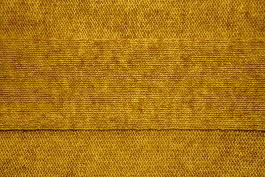Wool sweater texture close up. Knitted jersey background with a relief pattern. Braids in machine knitting pattern