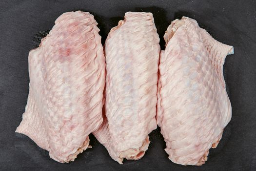 Raw turkey wings on black Slate Tray. Fresh turkey wingette on a black stone tray