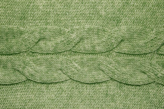Wool sweater texture close up. Knitted jersey background with a relief pattern. Braids in machine knitting pattern