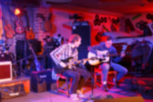 Musicians in a nightclub. Band performs on stage, rock music concert in a nightclub, blurred