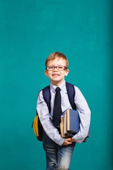 Book, school, kid. little student holding books. Cheerful smiling little kid with big backpack against chalkboard. Looking at camera. School concept. Back to School
