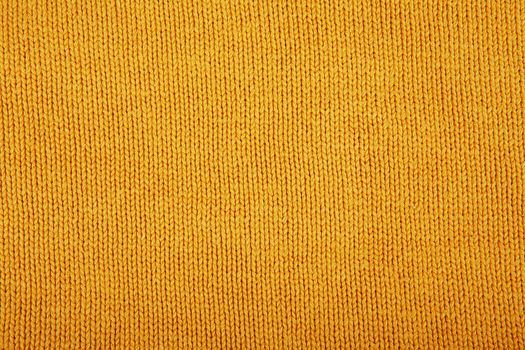 Wool sweater texture close up. Knitted jersey background with a relief pattern. Braids in machine knitting pattern
