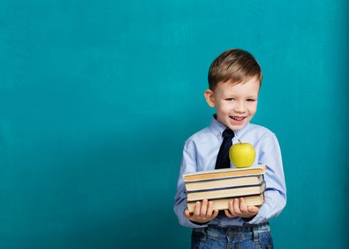 Book, school, kid. little student holding books. Cheerful smiling little kid against chalkboard. Looking at camera. School concept. Back to School