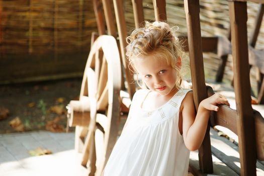 Portrait of an adorable preschool age girl with a hairdo with hairpins on her head. Positive emotions. Happy child.