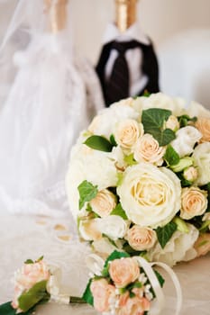 Elegant bridal bouquet and groom's boutonniere of roses and and decorated champagne bottle