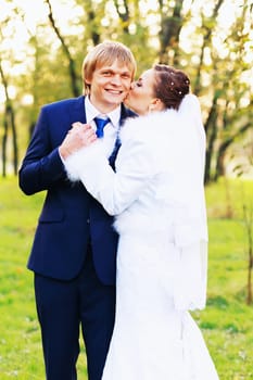 Photo of happy newlyweds outdoors. Beautiful young bride and groom in love.