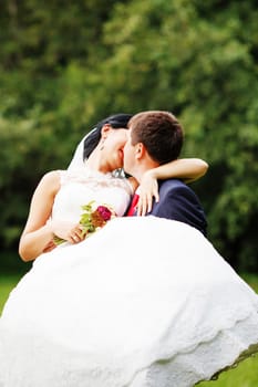 Photo of happy newlyweds outdoors. Beautiful young bride and groom in love.