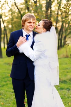 Photo of happy newlyweds outdoors. Beautiful young bride and groom in love.