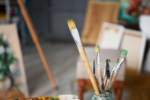 oil paints and paint brushes on a palette. Closeup of painting brushes