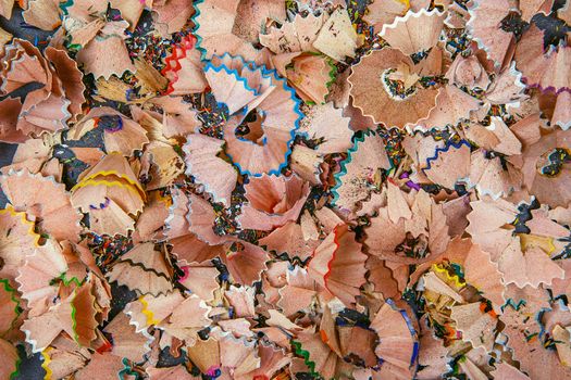 Background of multicolor pencil shavings. Close up colorful pencil shavings for background. Dynamic, abstract, horizontal composition of pencil sharpening shavings, close up, macro