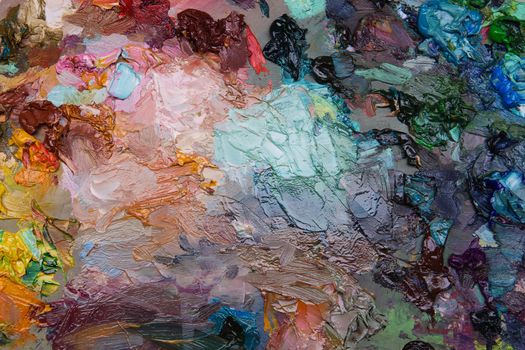 artists oil paints on wooden palette. macro artist's palette, texture mixed oil paints in different colors and saturation. art palette background