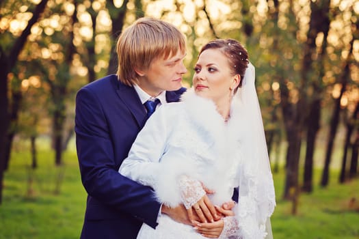 Photo of happy newlyweds outdoors. Beautiful young bride and groom in love.