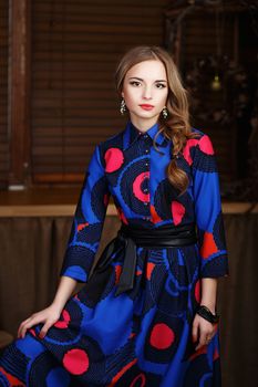 Portrait of a beautiful long-haired young girl in fashion motley dress