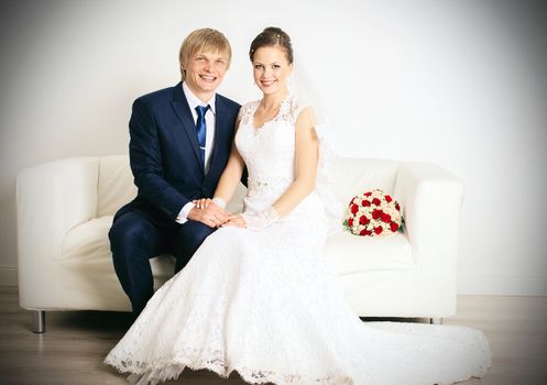 Laughing couple. Wedding photo of happy newlyweds in the total white studio