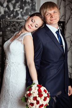 Bride and groom in studio with vintage interior. Photo of happy newlyweds. Beautiful fashion bridal couple