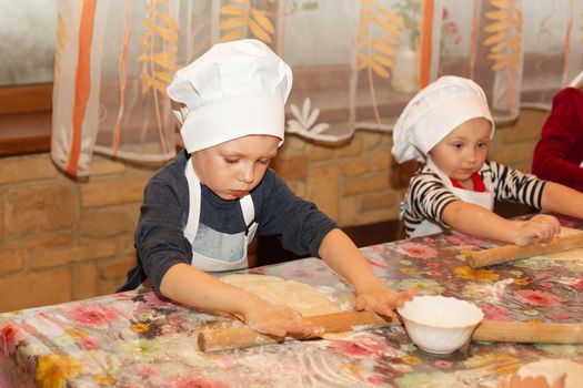 Little cook. Children make pizza. Master class for children on cooking Italian pizza. Young children learn to cook a pizza. Kids preparing homemade pizza