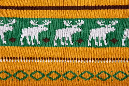 Christmas ornamental knitting with deers. knitted sweater background texture. Real knitted fabric textured background