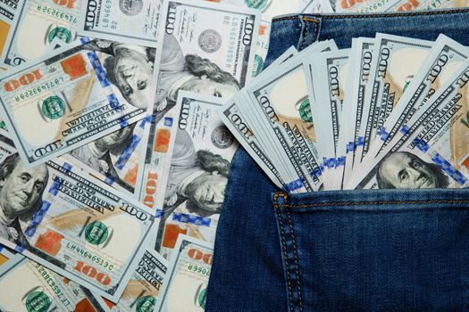 Several of banknotes hundred dollars of USA sticking out of his jeans pocket. dollars in the pocket of jeans.