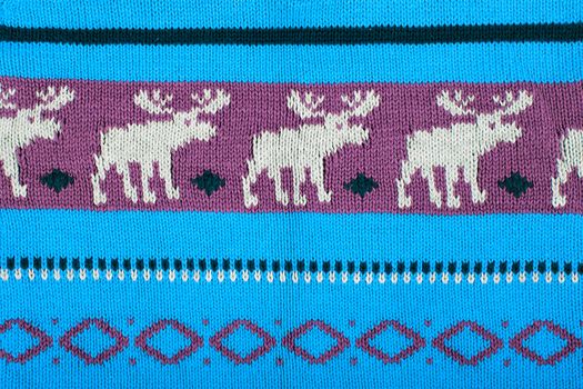 Christmas ornamental knitting with deers. knitted sweater background texture. Real knitted fabric textured background