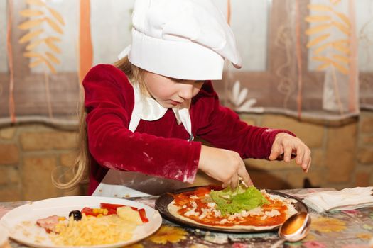 Children make pizza. Master class for children on cooking Italian pizza. Young children learn to cook a pizza. Kids preparing homemade pizza. Little cook.