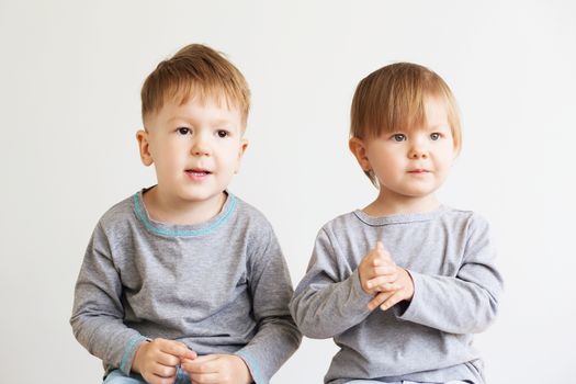 Two little kids. Portrait of a happy little children - boy and girl. Beautiful kids against a white background