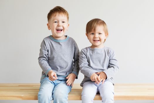 Two little kids. Portrait of a happy little children - boy and girl. Beautiful kids against a white background