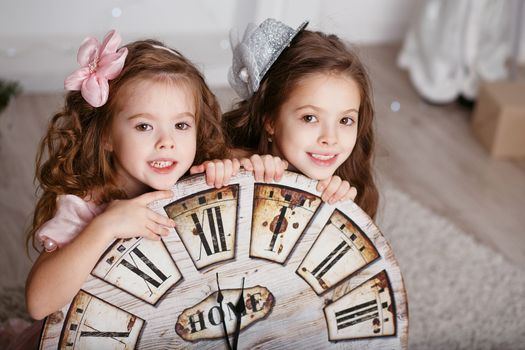 Portrait of Beautiful little girls with a big clock waiting for the new year. New year preparation