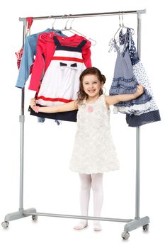 Little fashionable girl chooses clothes in a wardrobe Isolated on white background