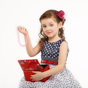 little girl admires the accessories in the box isolated on white background