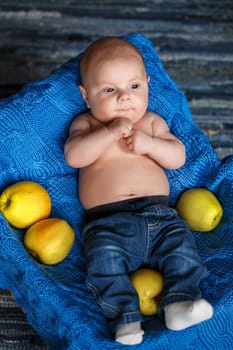 little boy lying in a basket with yellow apple