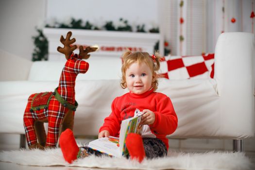 Little baby girl waiting for a miracle in Christmas decorations