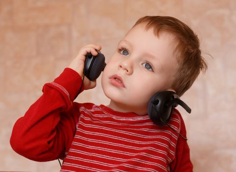 Little boy with headphones listening to music and singing