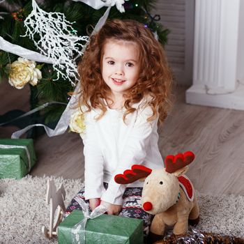 Portrait of a lovely little girl. Portrait of cute little girl among Christmas decorations