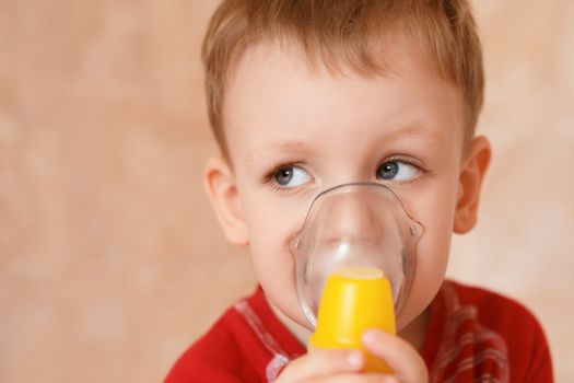 Sick child makes himself inhalation mask for breathing at home