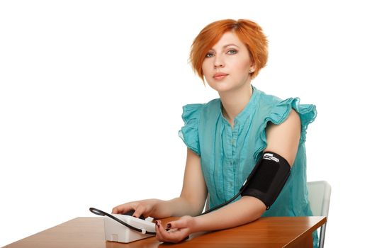 Young women measuring herself pressure with a tonometer isolated on white background