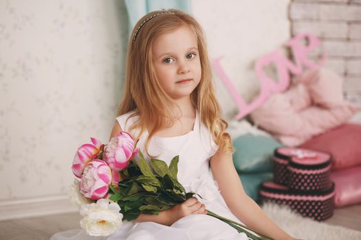 Portrait of a beautiful little girl with flowers