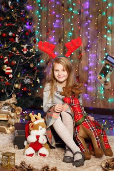 Beautiful Little girl waiting for a miracle in Christmas decorations