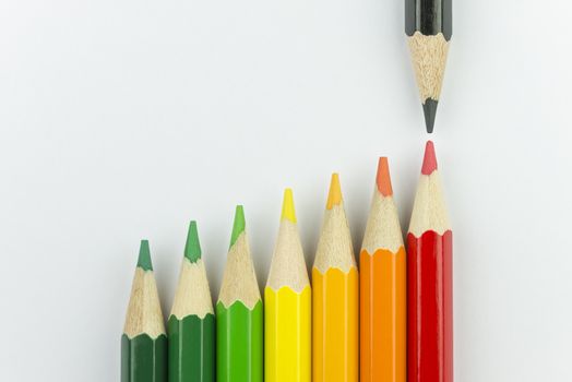 Conceptual crayons represented as successor energy label colors with black pencil that indicates the energy label
